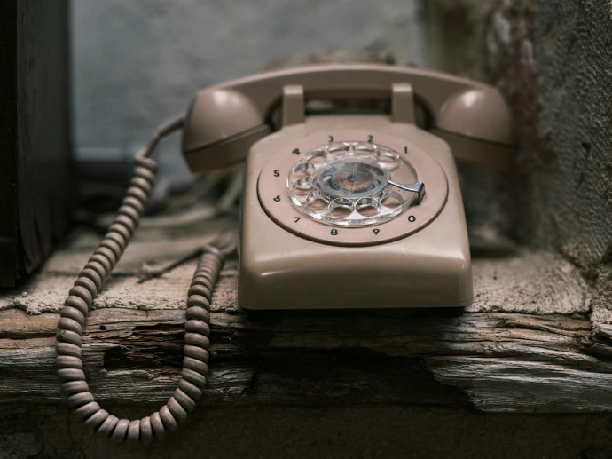 an old fashioned phone sitting on a window sill